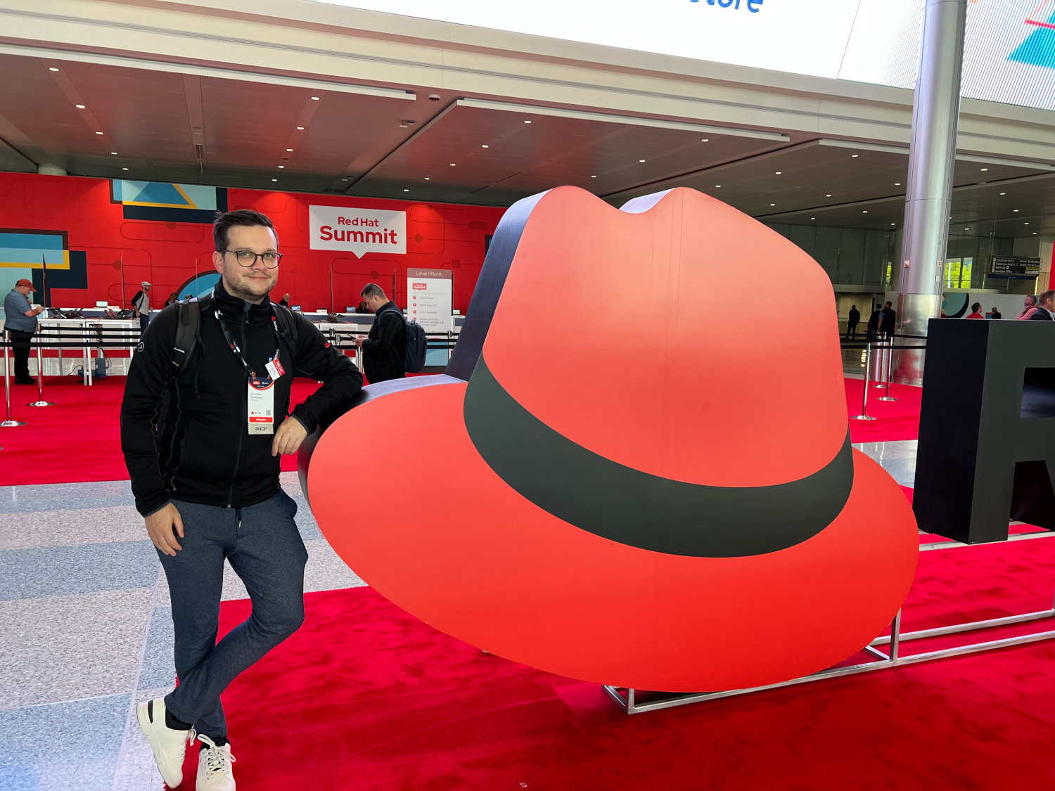 Ich neben einem großen Red Hat-Logo